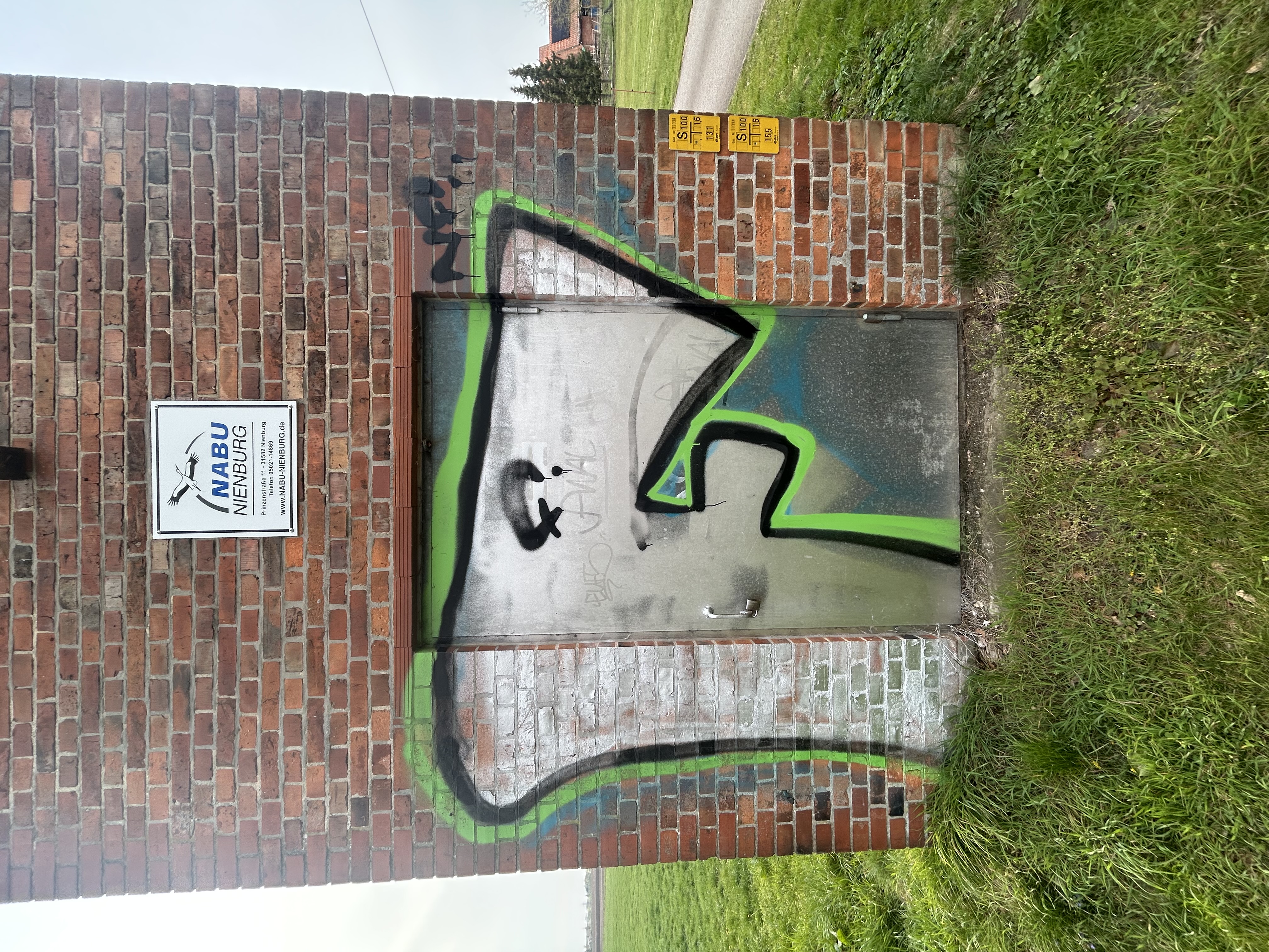 Vorher: Mehrfarbiges Graffiti auf Klinker und Metalltür